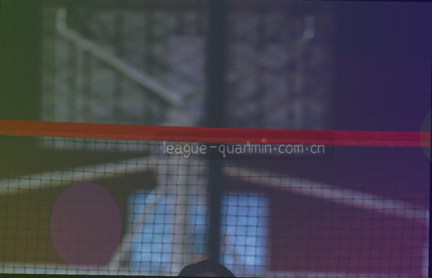 白天开放的社区五人制球场，围网与简易看台围住场地，场上有球队正在热身